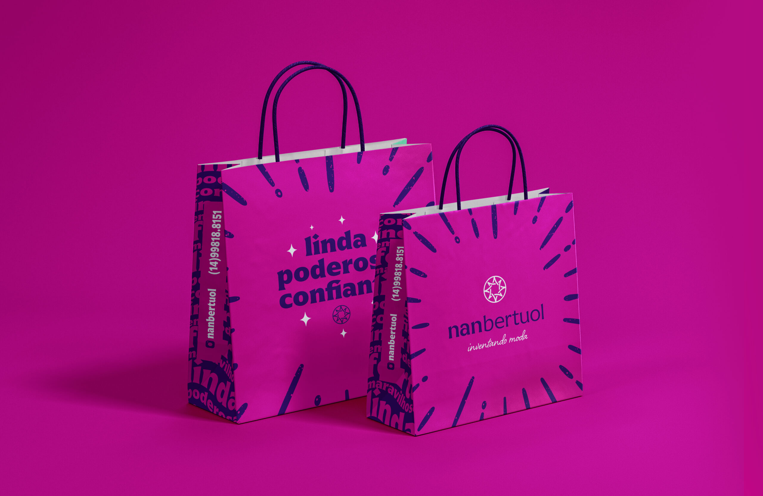 foto de duas sacolas rosas com grafismos da marca além de contar o logotipo em um lado e uma frase em outra (linda, poderosa e confiante).