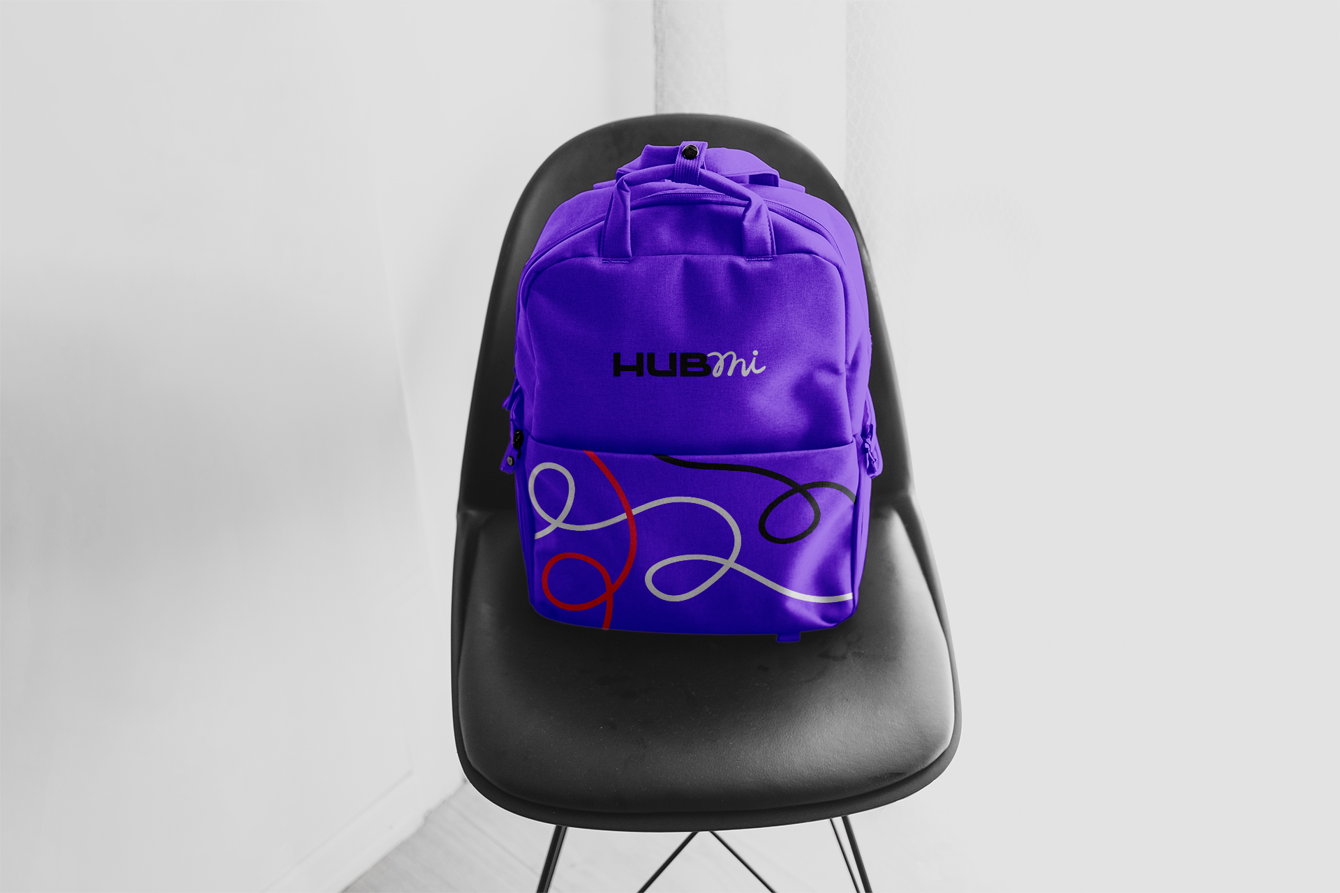 Imagem de uma mochila personalizada com a identidade visual da Hubmi, posicionada sobre uma cadeira, demonstrando a extensão da marca em acessórios práticos para o dia a dia.